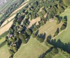 The cricket pitch, All Saints Church and Court Lodge Farm to the left side.
